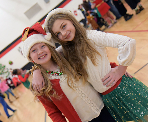  Cali Zahn and Emma Schlosser, sixth-graders at HMS, help host holiday party Dec. 14.